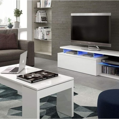 Móvel de TV branco moderno com televisão, mesa de centro branca com laptop, sofá cinza e tapete geométrico