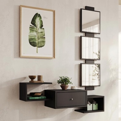 Móvel de parede preto com prateleira e gaveta decorado numa parede branca com espelhos e quadro folha verde