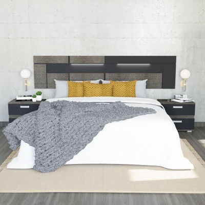 Cama de casal com roupa branca, almofadas amarelas e mantas cinzentas, mesas de cabeceira pretas e parede branca