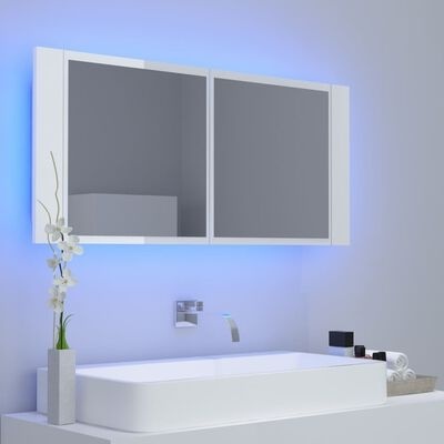 Espelho com luz LED azul sobre lavatório branco com torneira e decoração minimalista