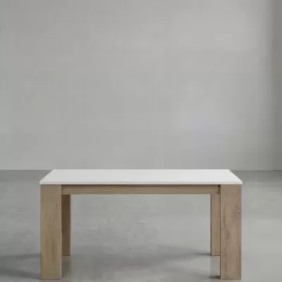 Mesa de jantar com tampo branco e pernas de madeira clara numa sala minimalista cinzenta