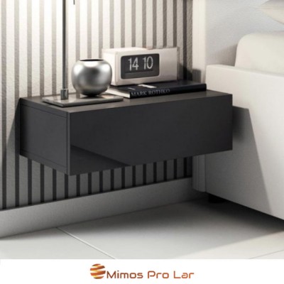 Mesa de cabeceira preta suspensa com decoração e relógio digital ao lado de sofá branco