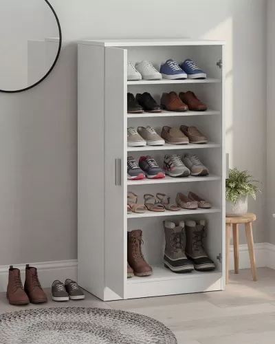 Móvel branco para arrumação de sapatos em ambiente interior com vários calçados distintos organizados nas prateleiras.