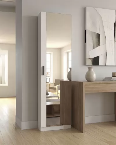 Roupeiro branco estreito com espelho numa divisão interior junto a secretária de madeira e vaso branco