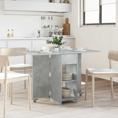 Mesa de refeições dobrável cinza cimento com cadeiras claras e louça branca numa cozinha moderna.