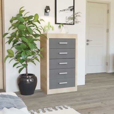 Cómoda com gavetas cinzentas e estrutura em madeira clara ao lado de planta verde e porta branca