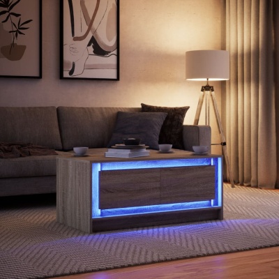 Mesa de centro em madeira clara com iluminação LED azul, sofá cinzento, almofadas, tapete bege e luminária de piso com base tripé