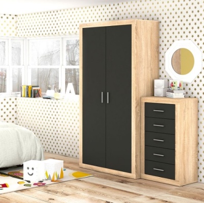 Armário e cómoda em madeira clara com portas pretas num quarto infantil com papel pintado de estrelas douradas