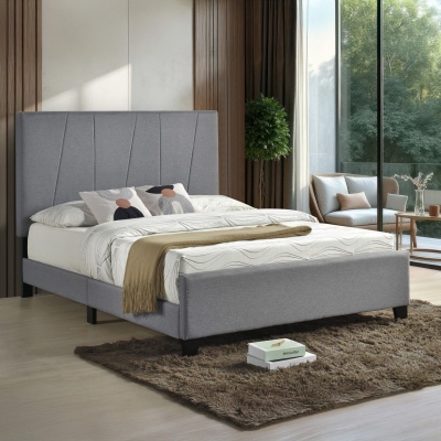 Cama estofada cinza com roupa de cama branca e almofadas decorativas num quarto moderno com tapete castanho.