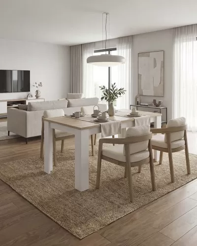 Sala de jantar com mesa branca, cadeiras de madeira clara estofadas em bege, sofá e decoração neutra