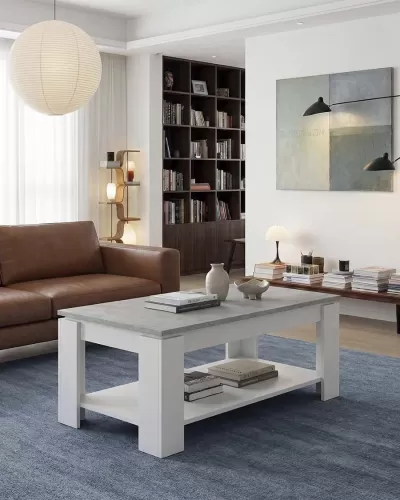 Mesa de centro com tampo cinza e estrutura branca numa sala moderna com sofá castanho e estante de livros