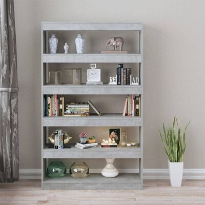 Estante cinzenta com livros, objetos decorativos e planta alta ao lado