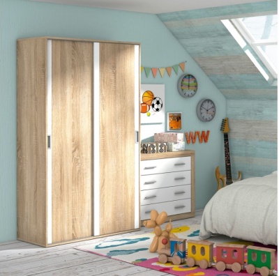 Quarto infantil com armário de madeira clara, cómoda branca, decoração de parede e brinquedos coloridos no tapete.