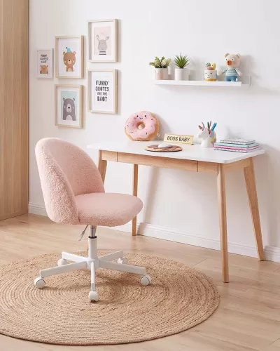 Cadeira rosa e mesa branca com decoração infantil e quadros na parede