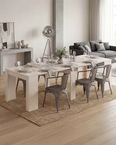 Mesa de jantar branca com cadeiras metálicas cinza e decoração, em sala com sofá cinza e tapete bege