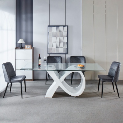Mesa de jantar com tampo de vidro e base branca em formato de laço com quatro cadeiras cinza escuro