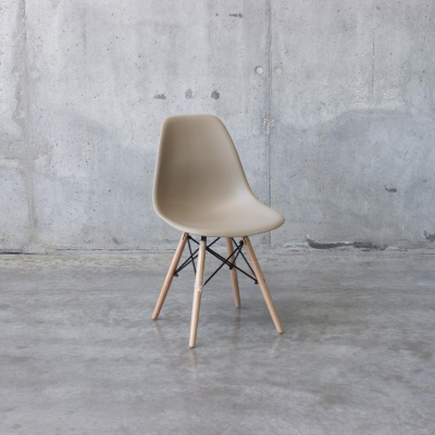 Cadeira bege de plástico com pernas de madeira sobre chão de cimento polido