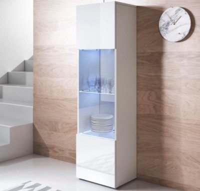 Armário branco para cozinha com prateleiras de vidro, copos e pratos, contra parede de madeira clara com relógio redondo branco de mármore.