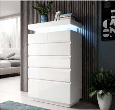 Móvel branco lacado com seis gavetas junto a parede de madeira escura e planta em vaso branco