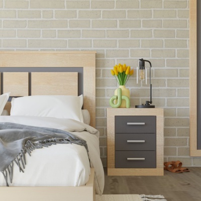 Quarto com cama de madeira clara, mesa de cabeceira com gavetas cinzentas, flores amarelas e candeeiro preto, parede de tijolos claros.