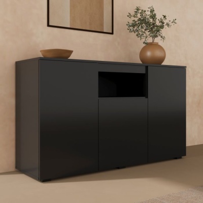 Aparador preto com três portas e nicho aberto, decorado com vaso e tigela castanha junto à parede bege
