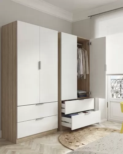 Dois roupeiros modernos em madeira clara e portas brancas, com gavetas abertas e roupas visíveis, num quarto claro com janela e tapete redondo