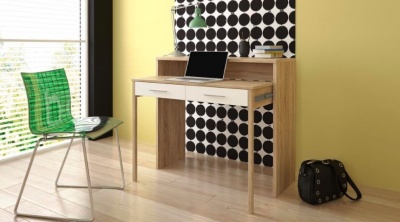 Secretária em madeira clara com duas gavetas brancas, cadeira verde, laptop e mala preta no chão