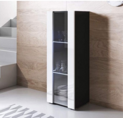 Móvel estreito com porta de vidro contendo louça, ao lado de escada e parede de madeira.