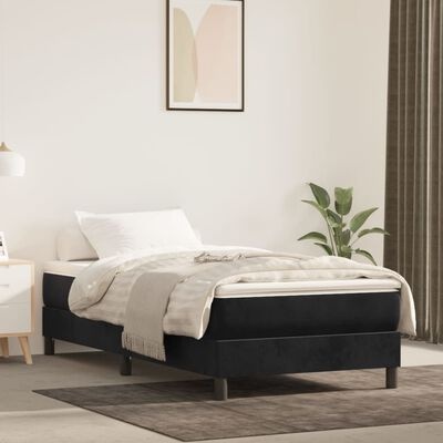 Cama individual com base preta e colchão branco em quarto minimalista