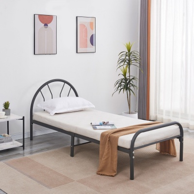 cama individual metálica preta com colchão branco e manta castanha em quarto decorado