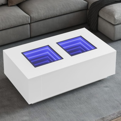 Mesa de centro branca com iluminação LED azul em nichos quadrados, sobre tapete cinzento junto a sofá cinzento