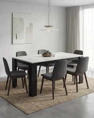 Sala de jantar com mesa branca, cadeiras cinzentas, tapete natural e lâmpada pendente