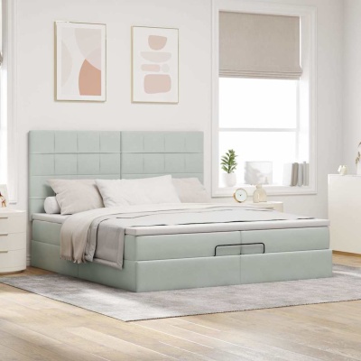 Cama de casal cinza claro com cabeceira estofada quadrada e roupa de cama clara num quarto minimalista.