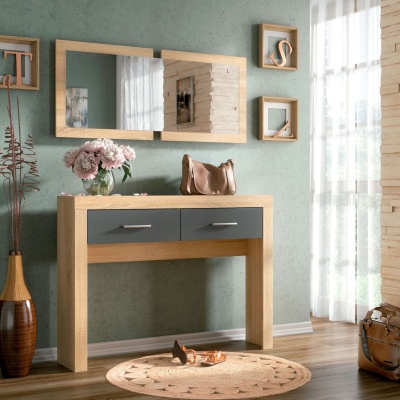 Móvel consola em madeira clara com gavetas cinzentas decorado com flores e espelhos na parede verde