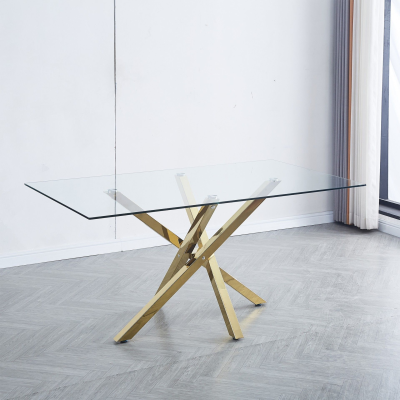 Mesa de jantar em vidro com base dourada, em ambiente interior com chão de madeira cinzenta