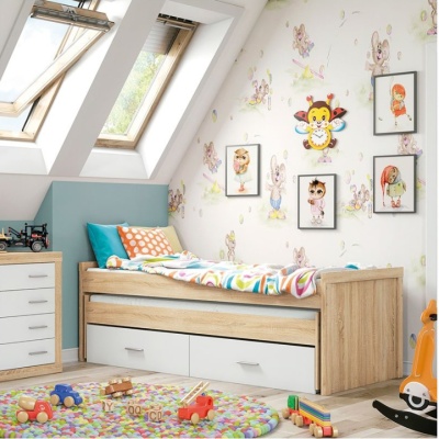 Quarto infantil com cama de madeira clara, gavetas brancas, e papel de parede com desenhos de coelhos