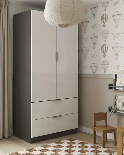 Guarda-roupa branco e cinza numa sala infantil com papel de parede de balões, tapete xadrez, cadeira de madeira e prateleiras com livros e brinquedos