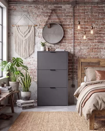 Quarto com cómoda cinza, espelho redondo, tapeçaria macramé, plantas em vasos, candeeiros suspensos e cama de madeira