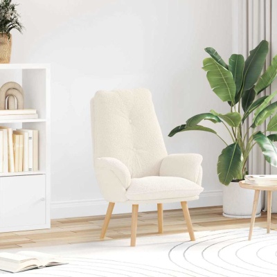 Poltrona branca de tecido felpudo com pernas de madeira em sala com estante, planta e mesa de madeira.