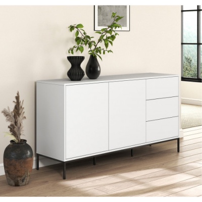 Móvel branco com portas e gavetas, vasos pretos e plantas numa sala com chão de madeira