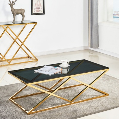 Mesa de centro com tampo de vidro preto e base metálica dourada em padrão geométrico sobre tapete cinzento claro
