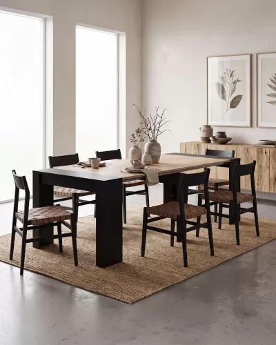 Mesa de jantar com seis cadeiras, vasos cerâmicos e decoração minimalista junto a parede com quadros botânicos