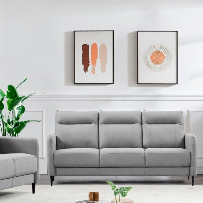 Sofá cinzento de três lugares com pinturas abstratas na parede branca