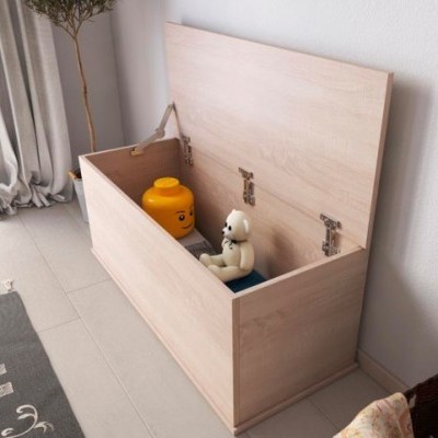 Caixa de arrumação de madeira clara aberta com brinquedos dentro ao lado de parede branca