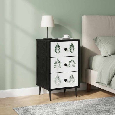 Mesa de cabeceira preta com gavetas brancas decoradas por folhas verdes ao lado de cama com almofada verde