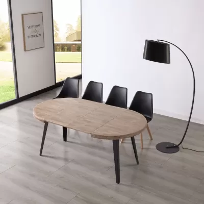 Mesa oval de madeira clara com cadeiras pretas e candeeiro preto de pé