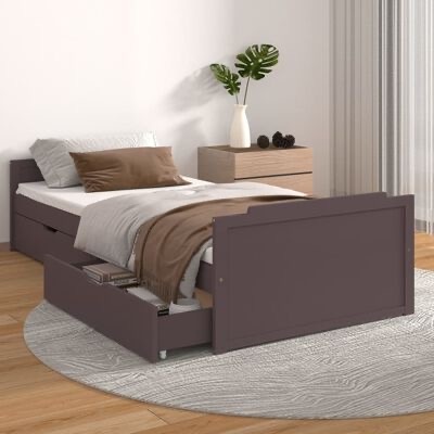 Cama individual de madeira castanha com gavetas abertas, roupa de cama branca e castanha, tapete cinza redondo e mesa de cabeceira com vaso e planta