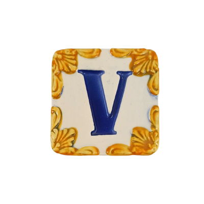 Azulejo cerâmico quadrado com letra V azul e borda amarelo-dourada