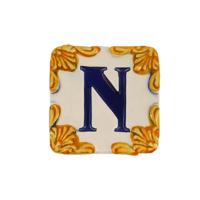 Azulejo decorativo com letra N azul e cantos dourados