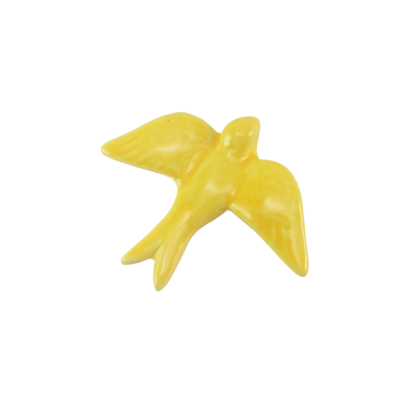 Pássaro decorativo amarelo em cerâmica sobre fundo branco